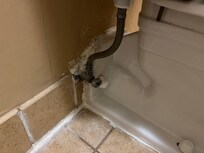The toilet pipes were surrounded by spackle that wasn't smooth or painted.