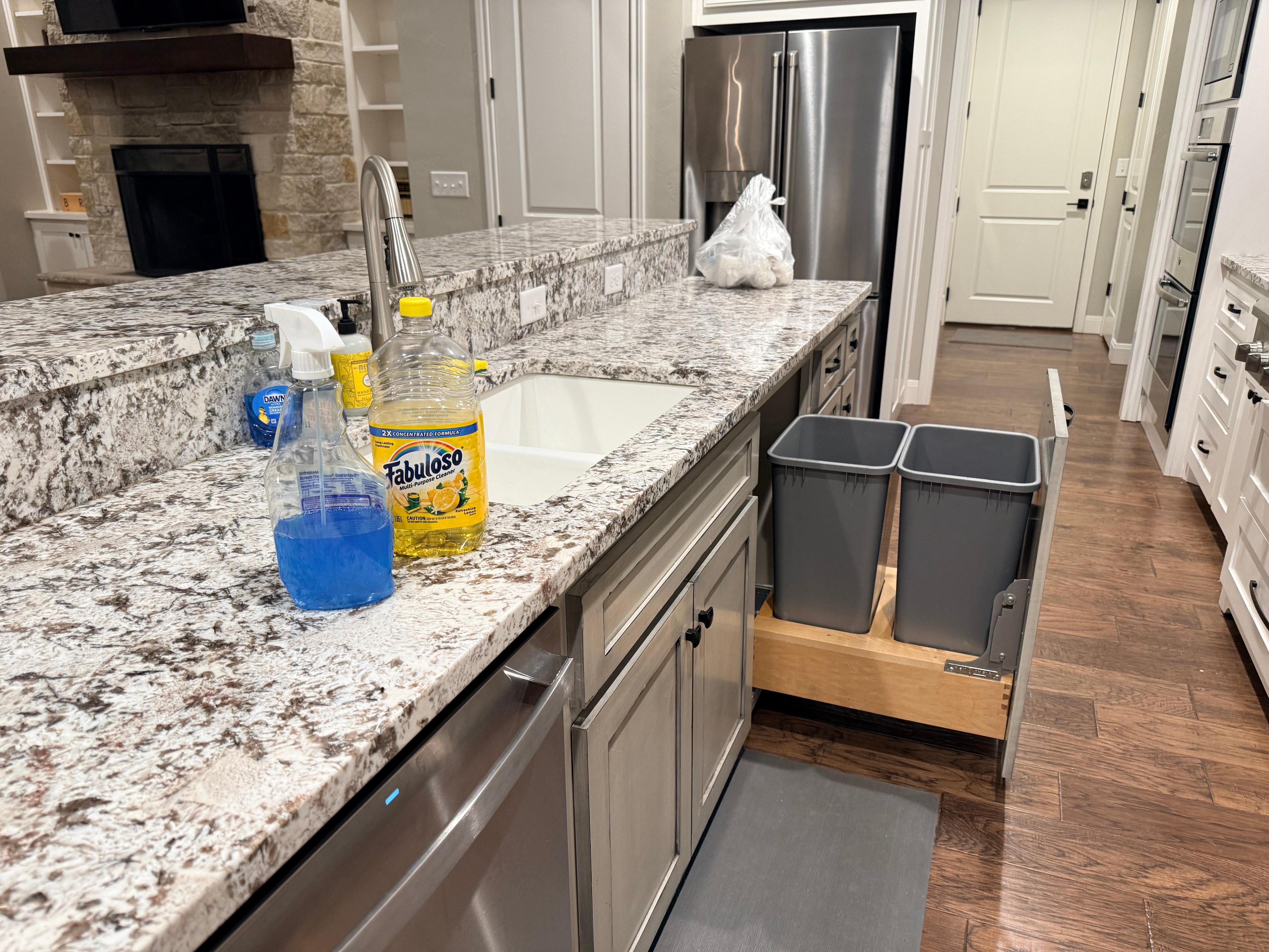 bag of trash and cleaning supplies left on kitchen counter
