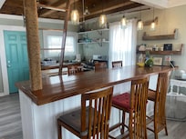 Kitchen area with stairs that lead up to a bedroom loft