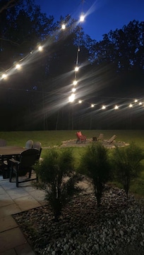 Backyard view of lights and fire pit