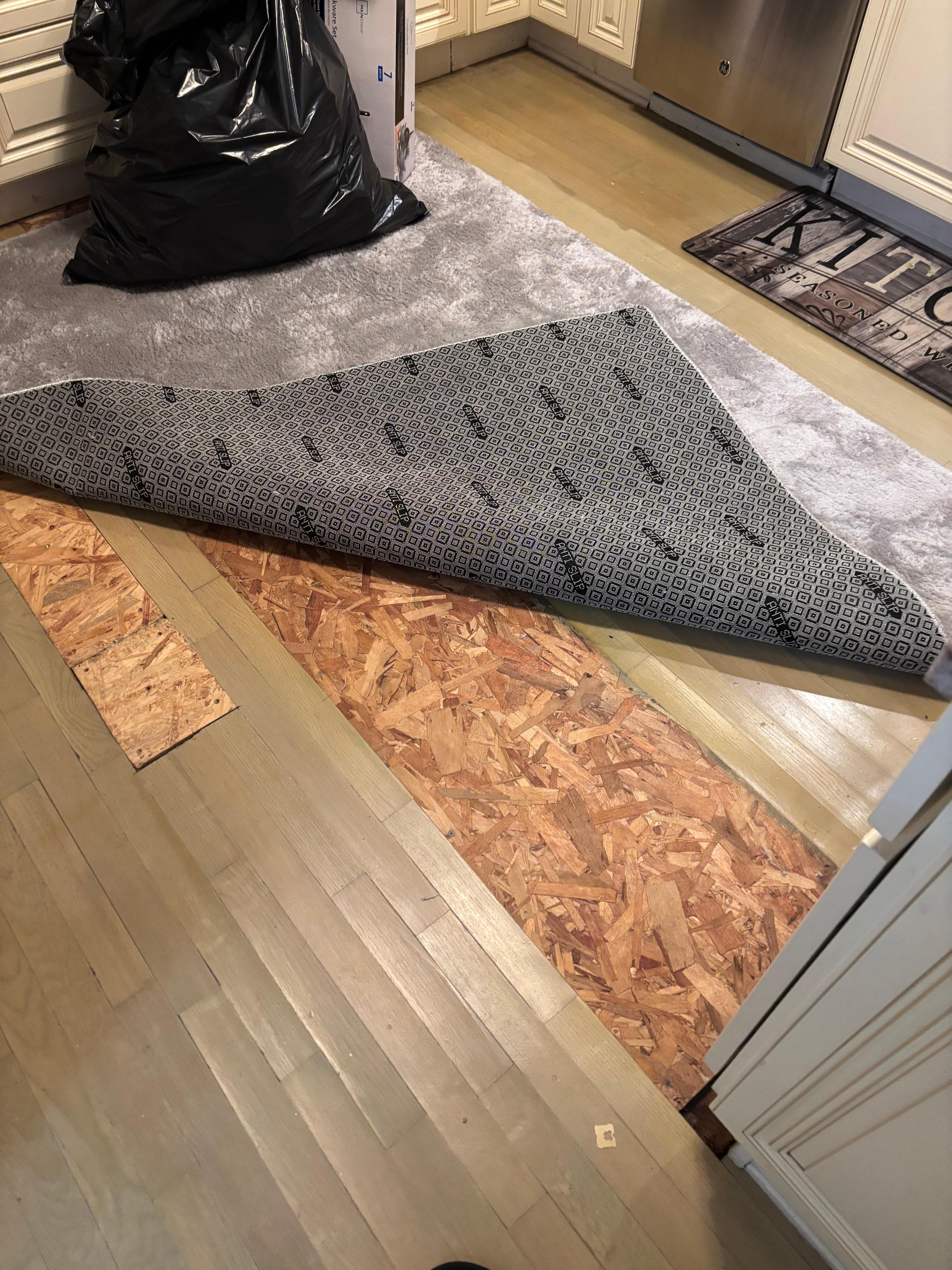 Water damage kitchen floor covered by rug.  Warp flooring in dining area from water damage 