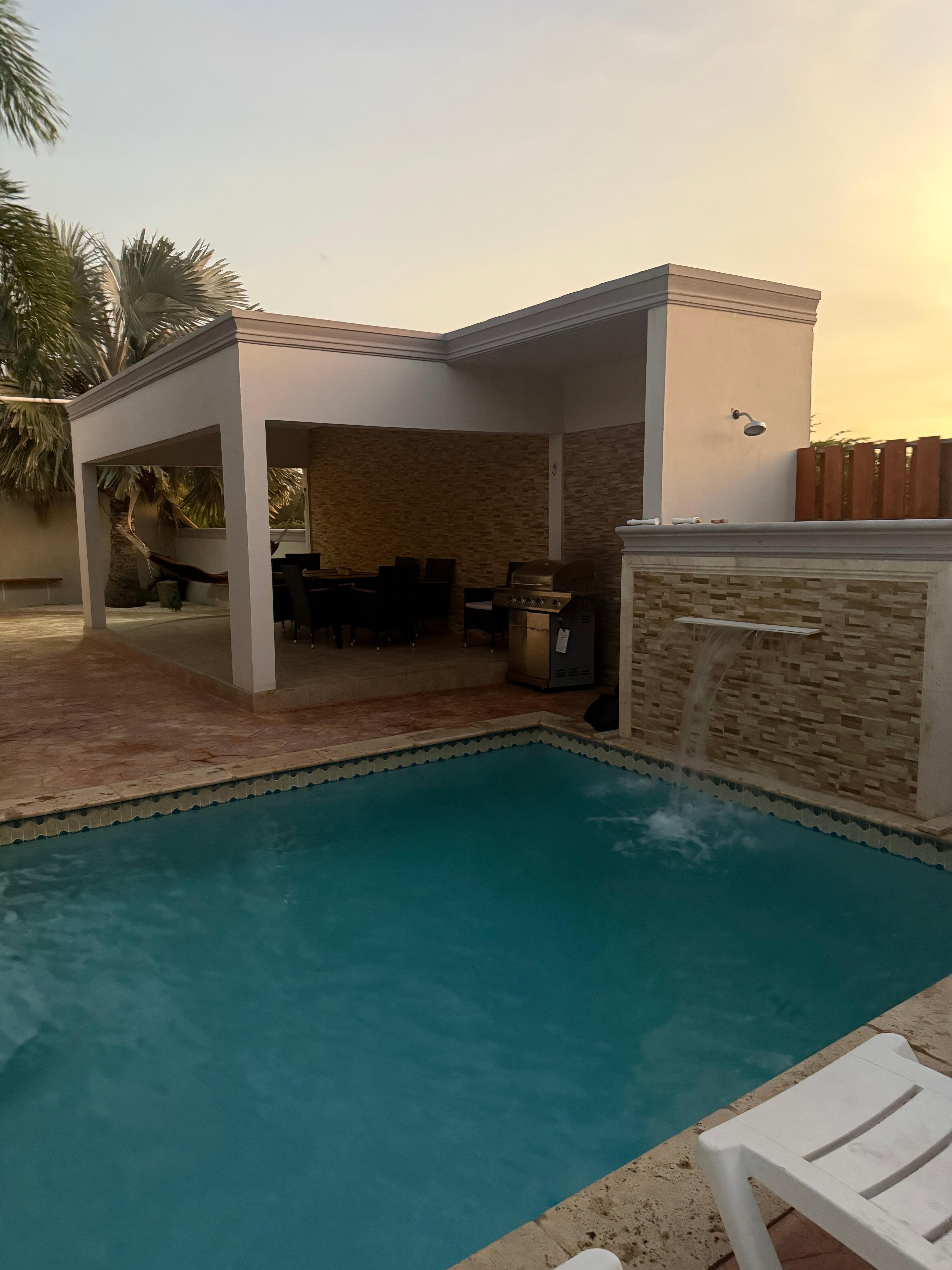 Pool, shower and outdoor dining area with a hammock. 