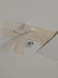Failing masking tape holding up damaged ceiling/cardboard.
