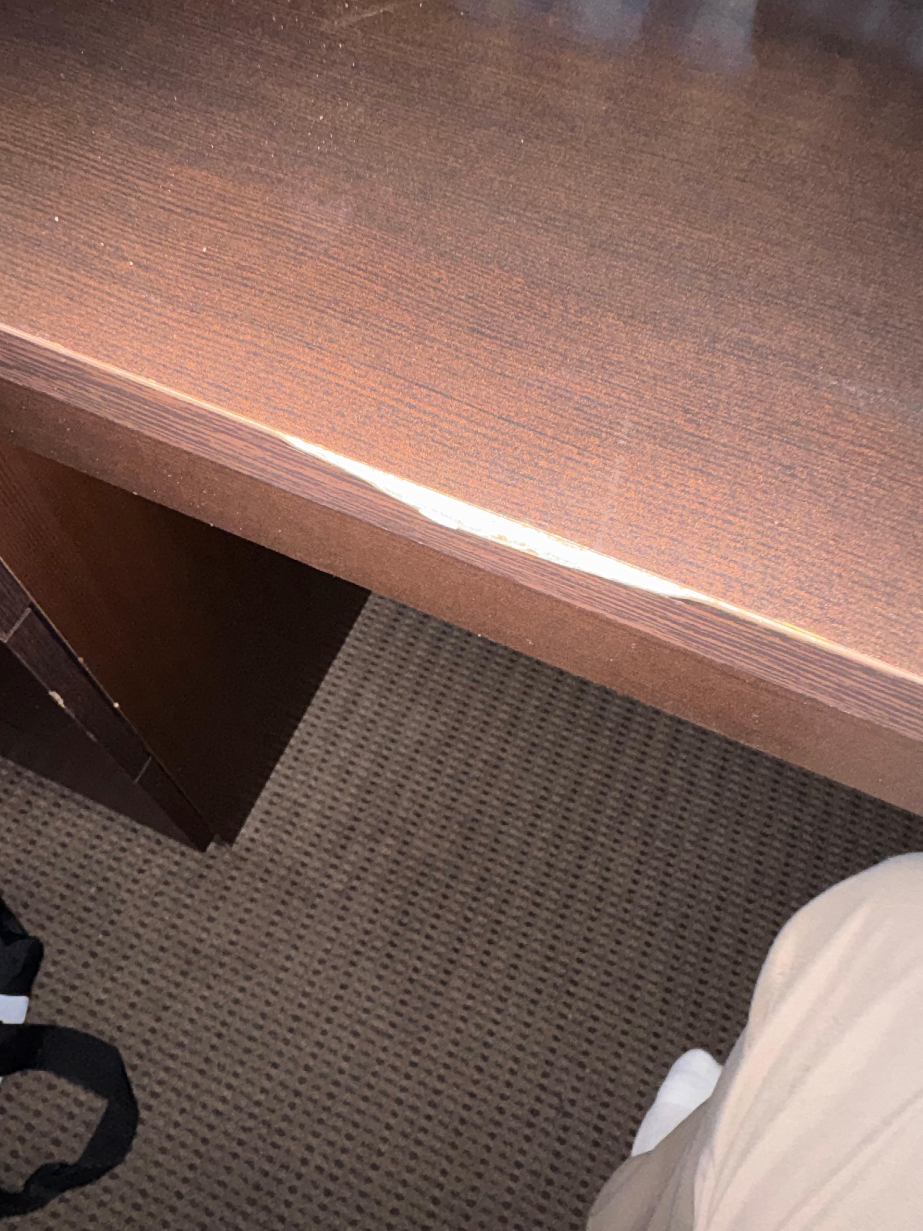 Siding of desk top that needs to be repaired.