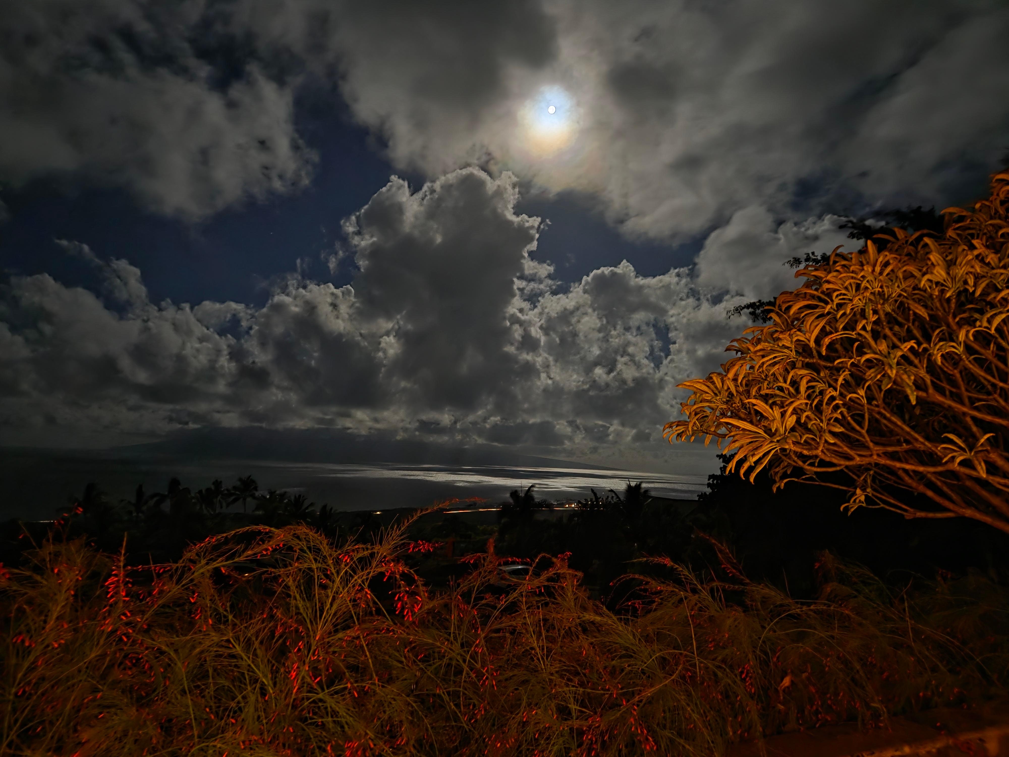 Moon setting over the ocean in the early morning.