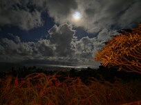 Moon setting over the ocean in the early morning.