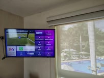 TV con cable y aplicaciones y vista a la alberca