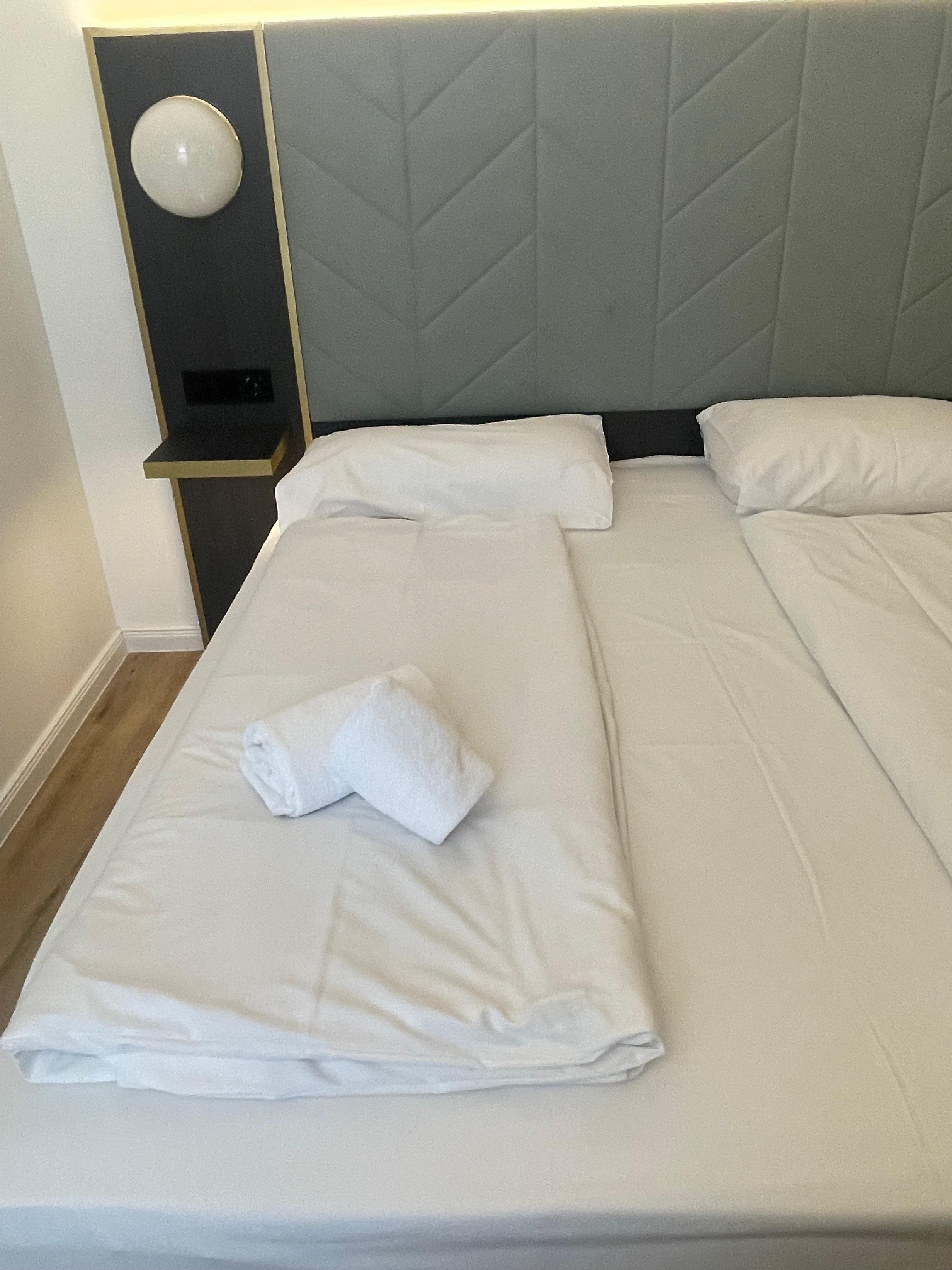 Dirty spots on the wall behind the bed. 