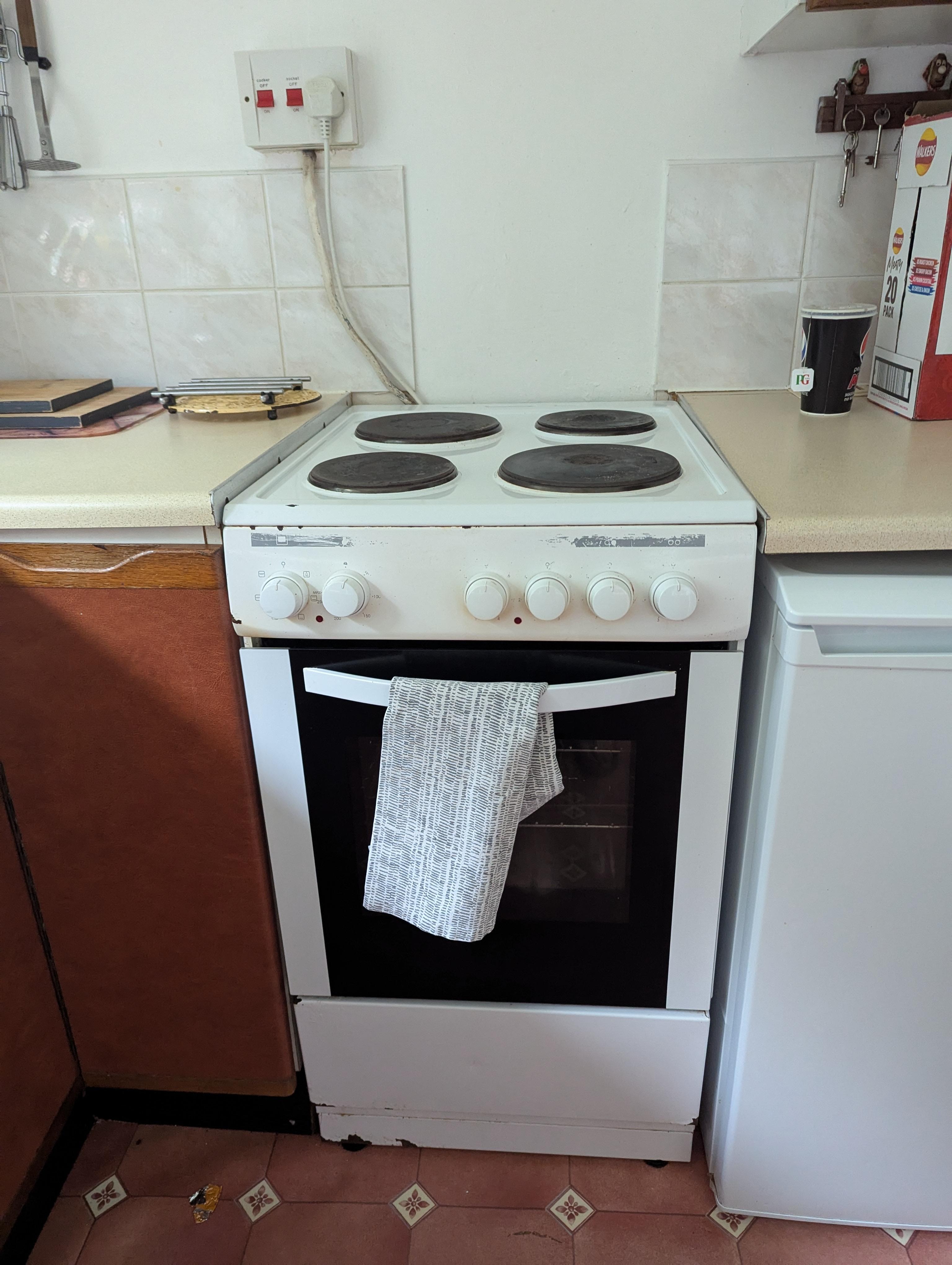 Fire Risk - Exposed cooker wire into wall mounted socket above cooker is not compliant with safety regs.