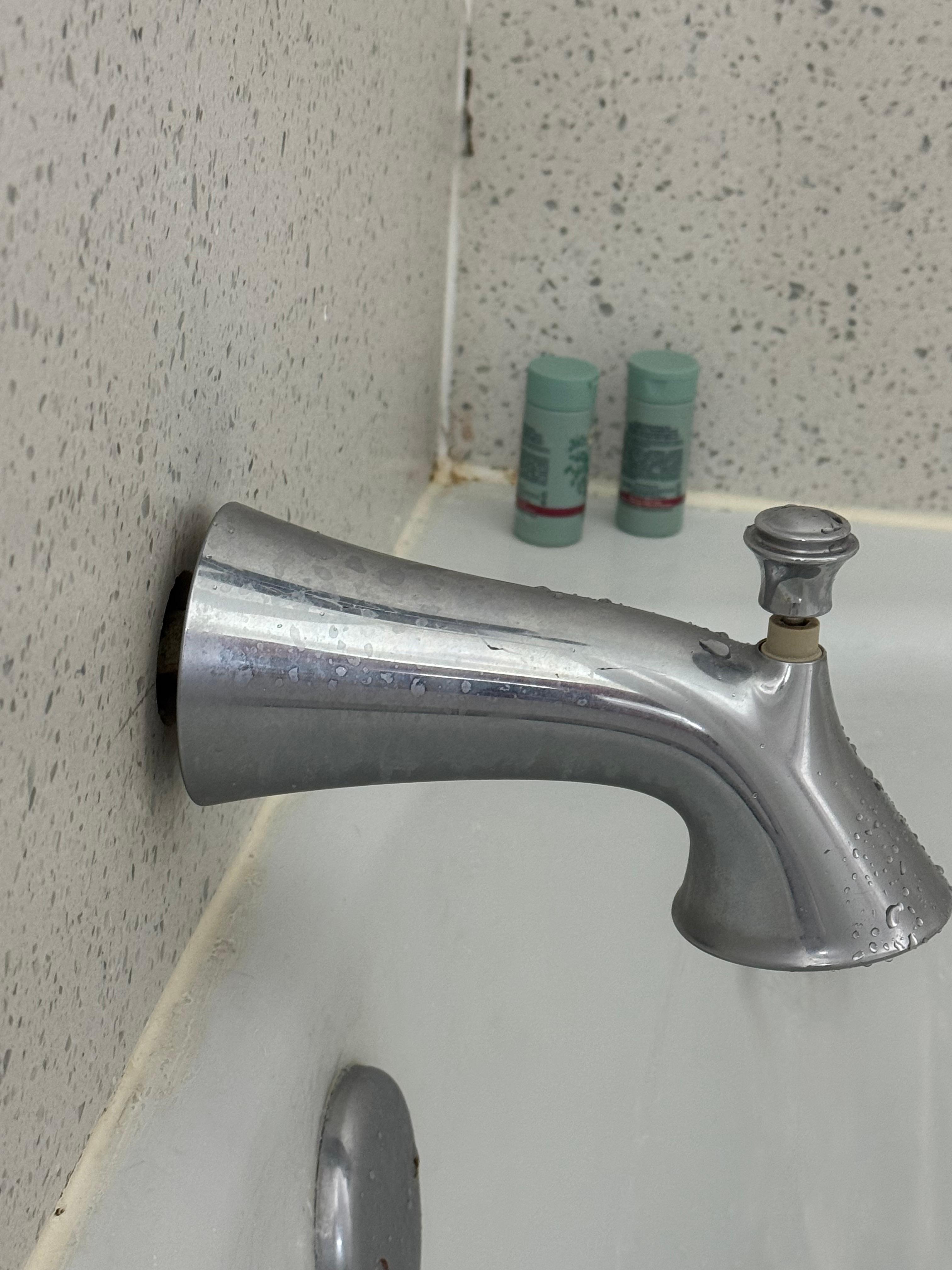 Not attached to the bathtub wall