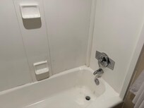 Shower and bathtub chipped. Mold covered up with thick gobs of poorly applied caulk.