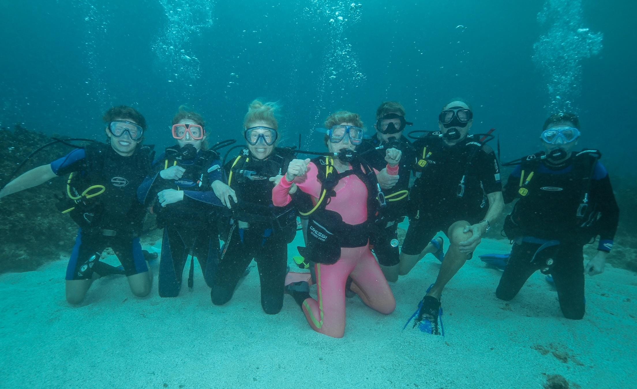 A three-generation-scuba-family photo. 81-year-old Grandma Connie in pink.