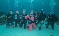 A three-generation-scuba-family photo. 81-year-old Grandma Connie in pink.