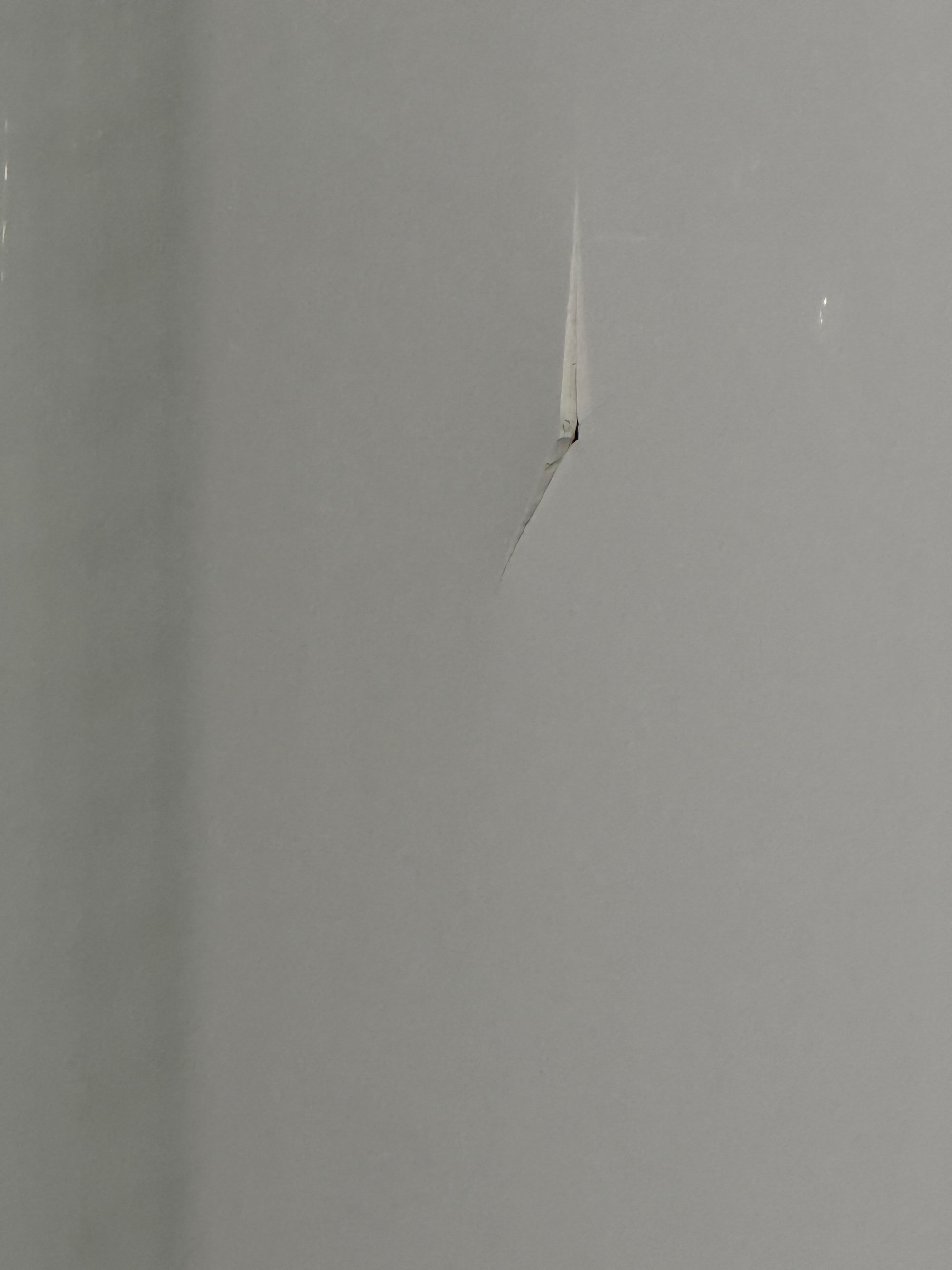 The shower insert has a crack on the opposite wall of the shower head.