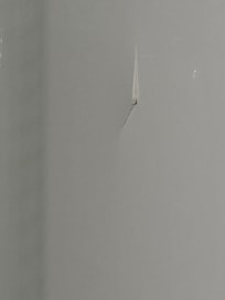 The shower insert has a crack on the opposite wall of the shower head.