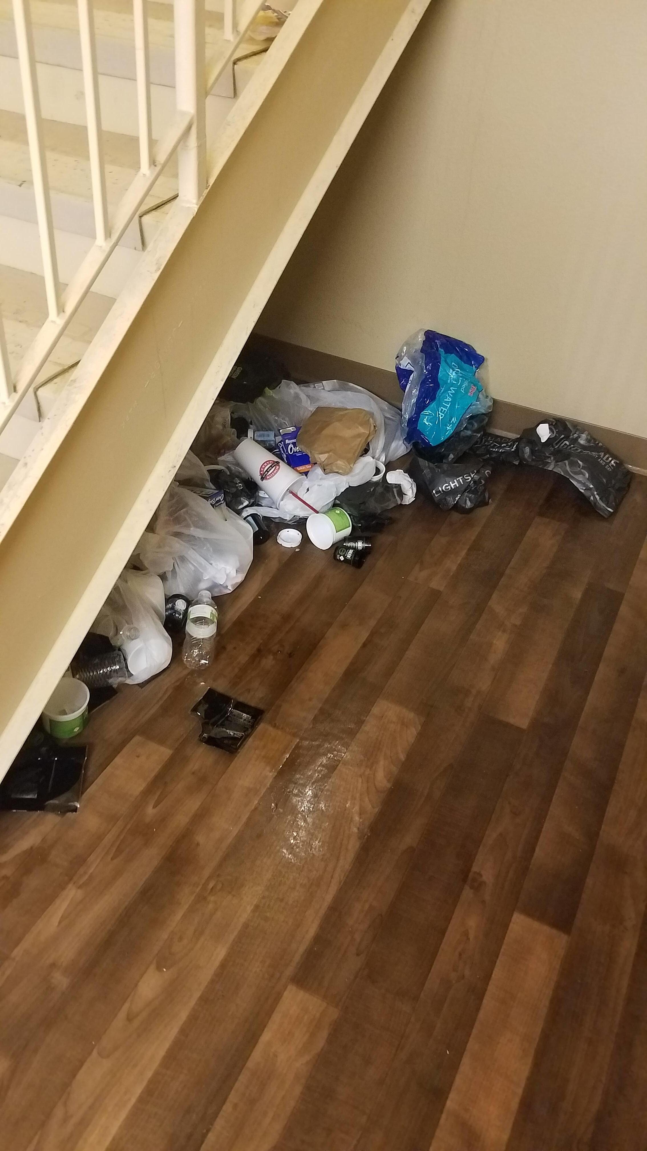 trash under stairs