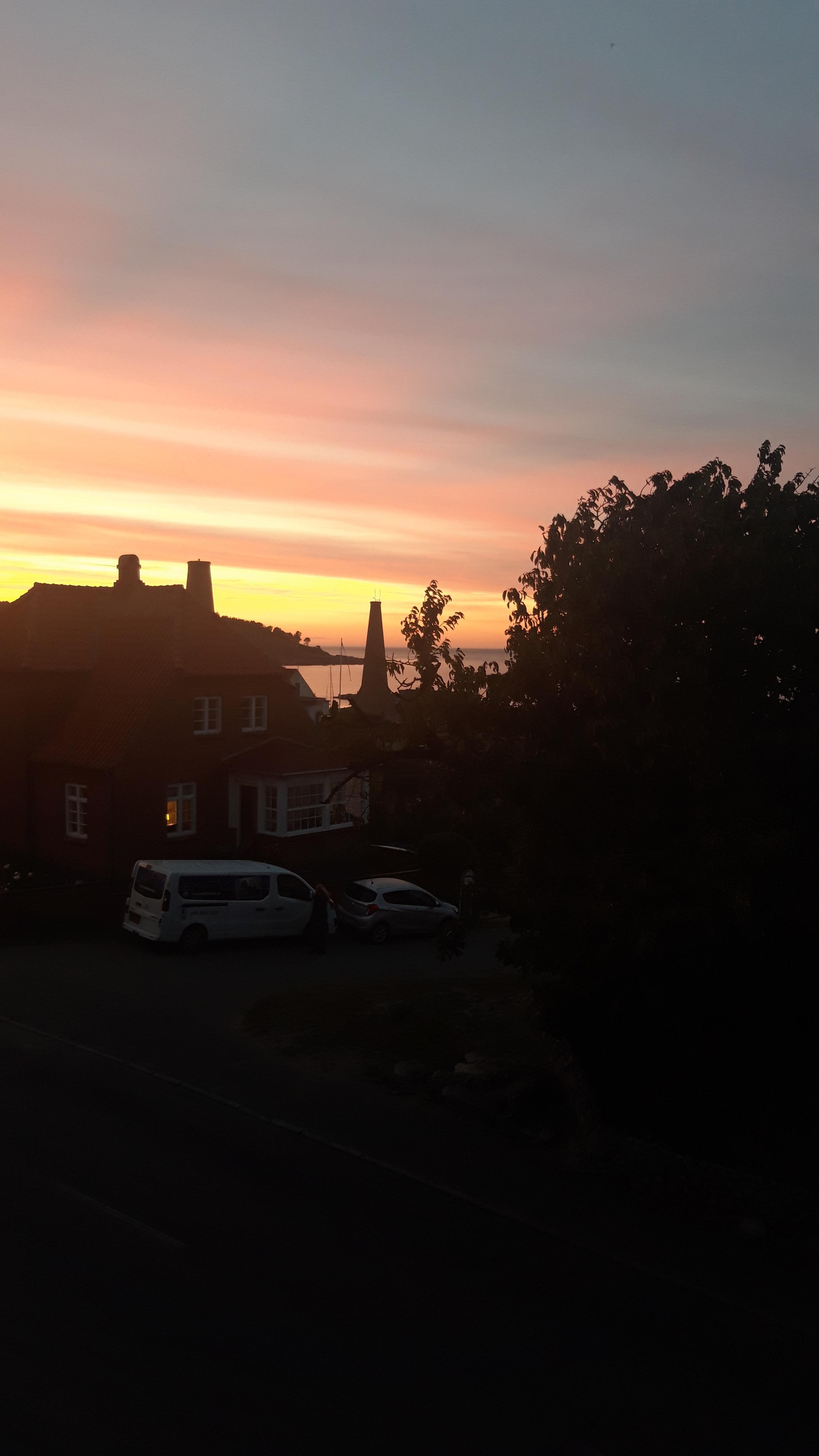 Solnedgang set fra lejlighedens vindue.