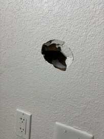 Hole in bathroom wall.