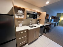Kitchen with full size fridge, sink with garbage disposal, dish washer, microwave.