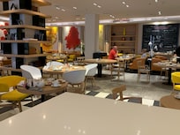 Sala de desayuno con muchas mesas sucias.