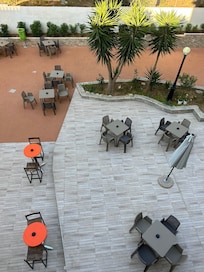 View from the balcony overlooking eating area outdoor bar and pool