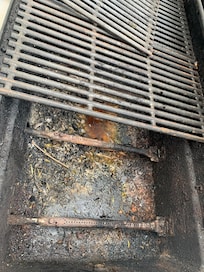 Terriblemente sucio asador con basura, insectos y gusanos.