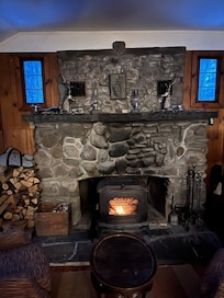 Beautiful stone fireplace with a well stocked supply of dried, split firewood. Woodstove warmed the cozy cabin comfortably.