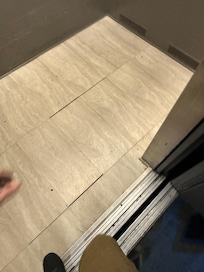 Sticky and stained elevator with floor tiles loose