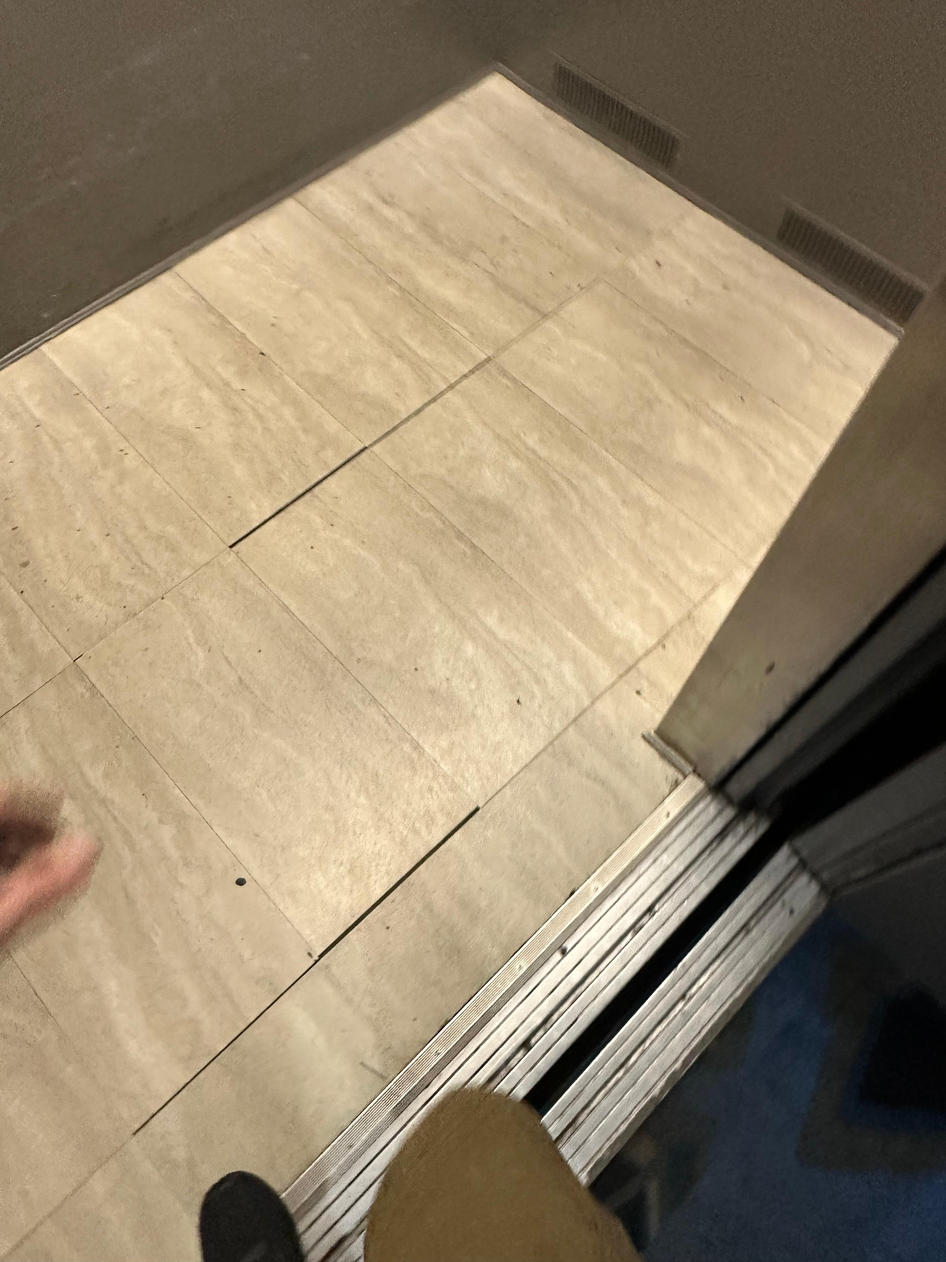Sticky and stained elevator with floor tiles loose