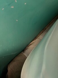 Dirt and hair behind the bed/mattress.