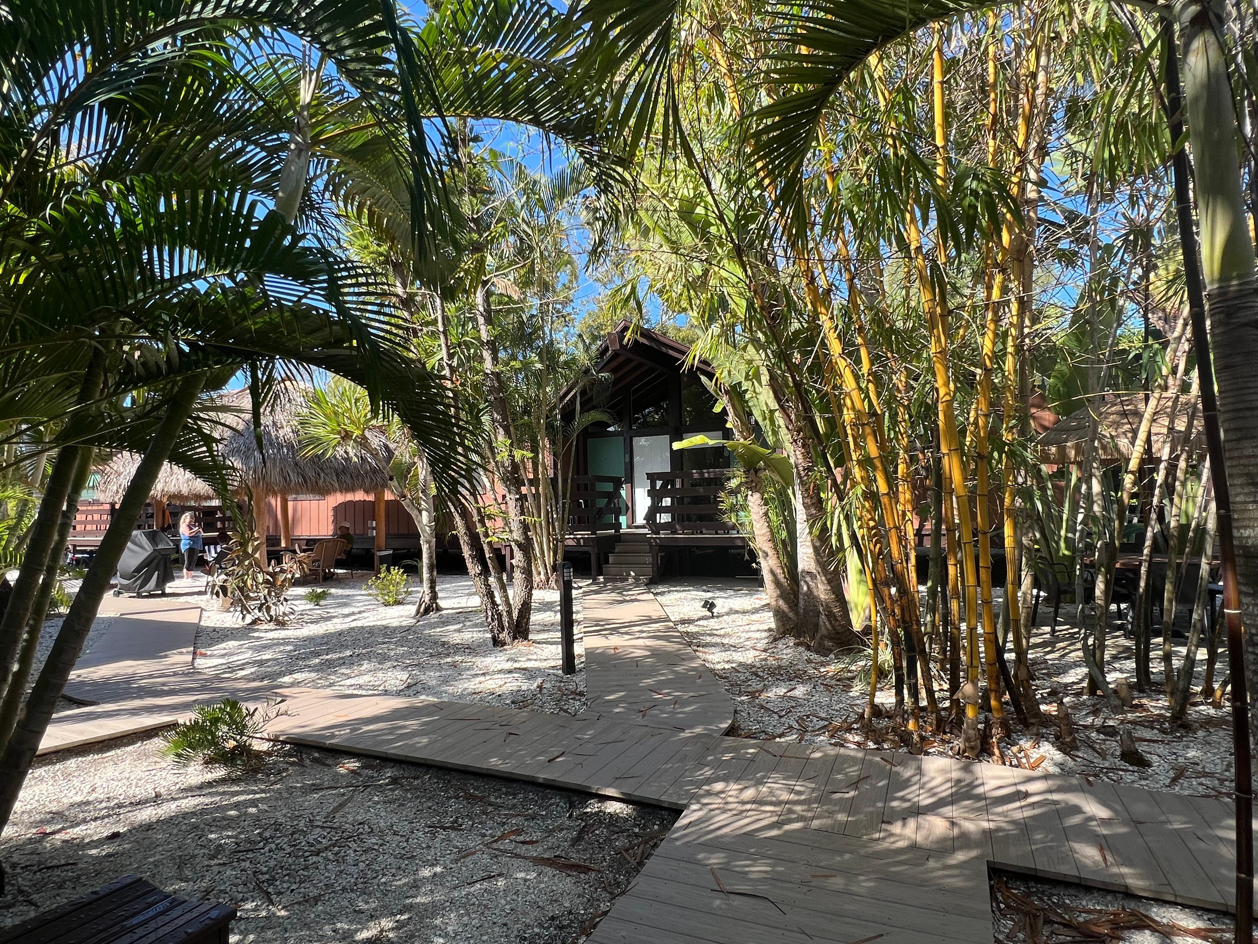 Shaded boardwalk path among the rooms