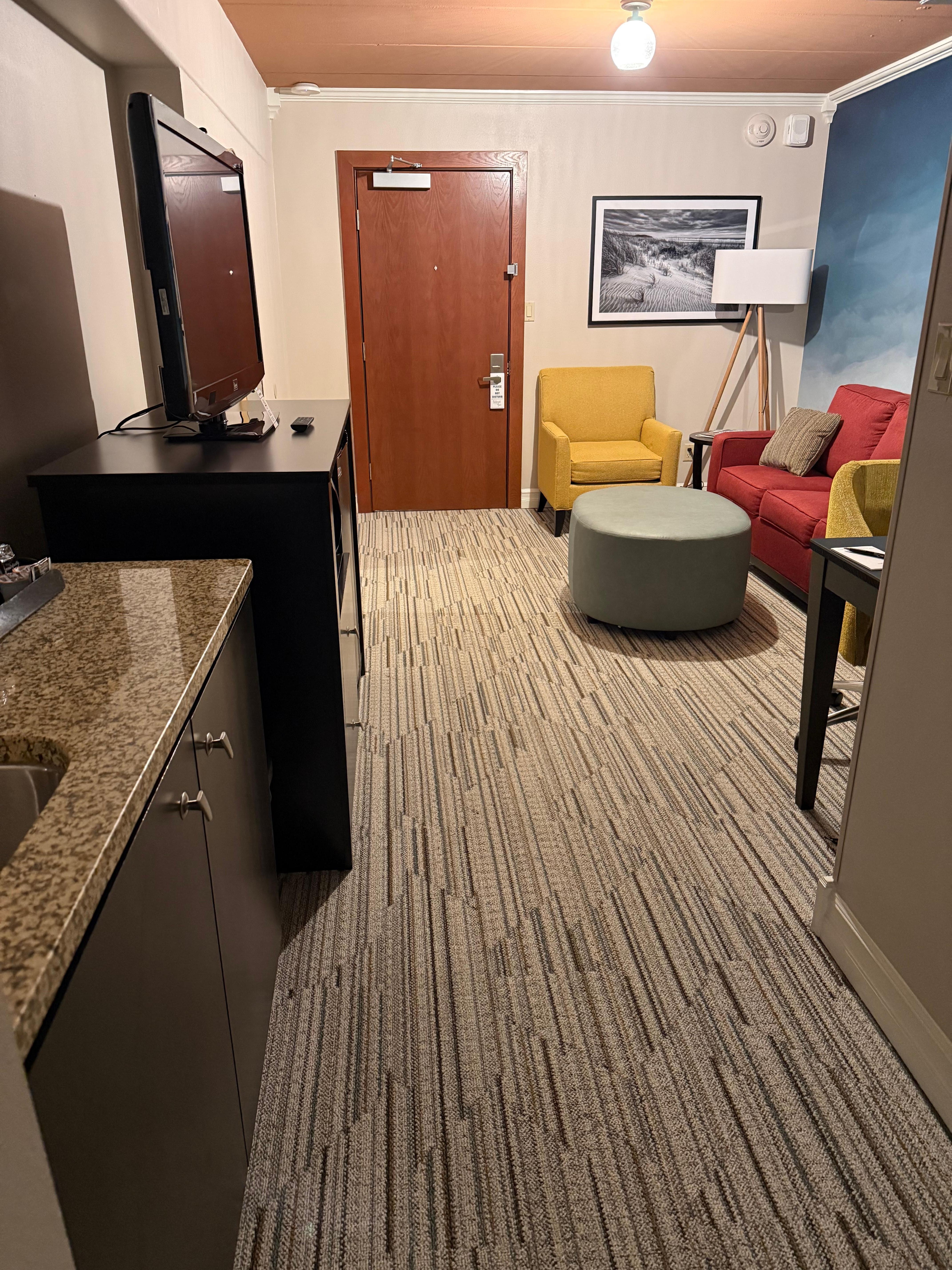 Nice desk with a phone, mini fridge, full length mirror, couch. 