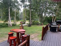 Outdoor table, canoe, grill and fire pit along the river.