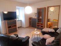 Gemütliches Wohnzimmer mit Blick ins kleinere Schlafzimmer