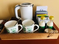 Tea tray with a lovely selection of teas and bottles of milk.