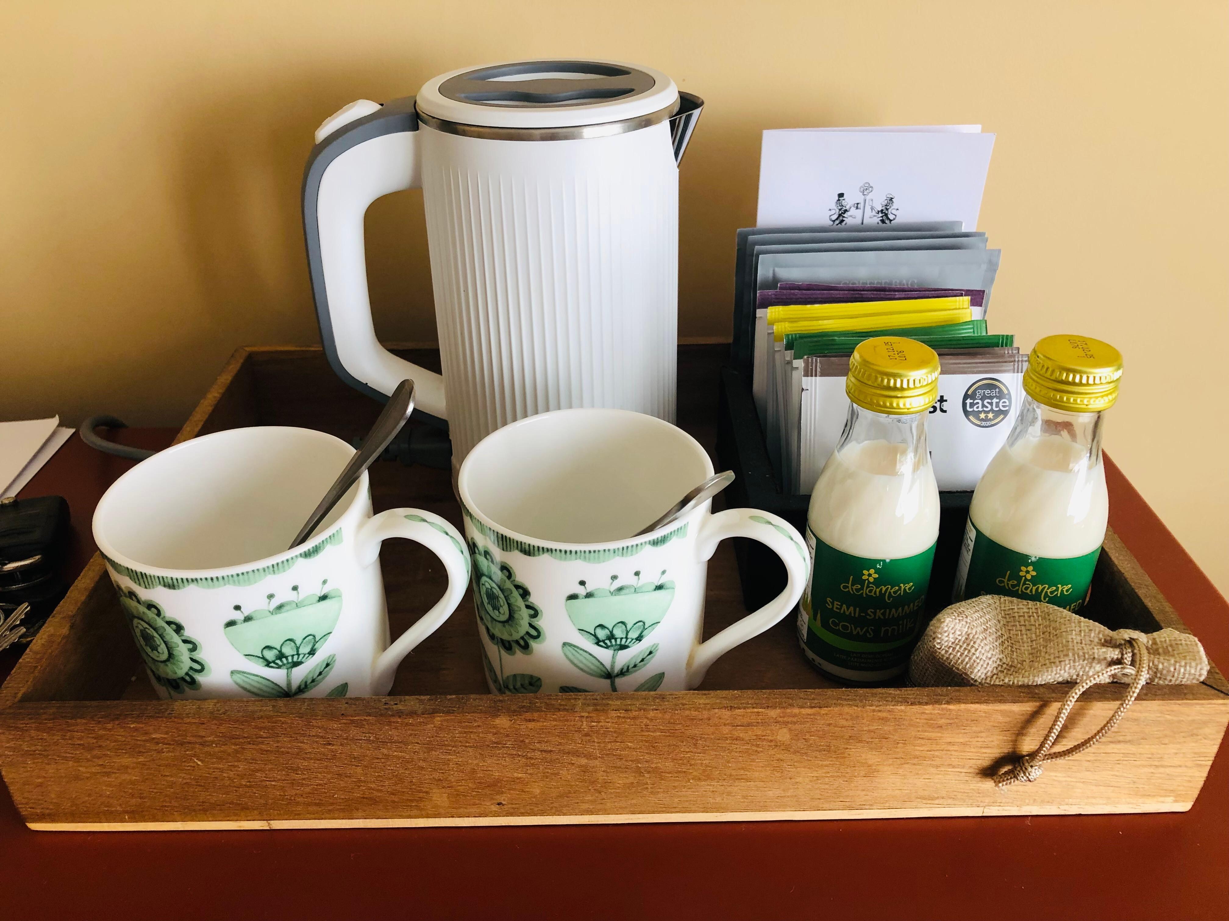Tea tray with a lovely selection of teas and bottles of milk.