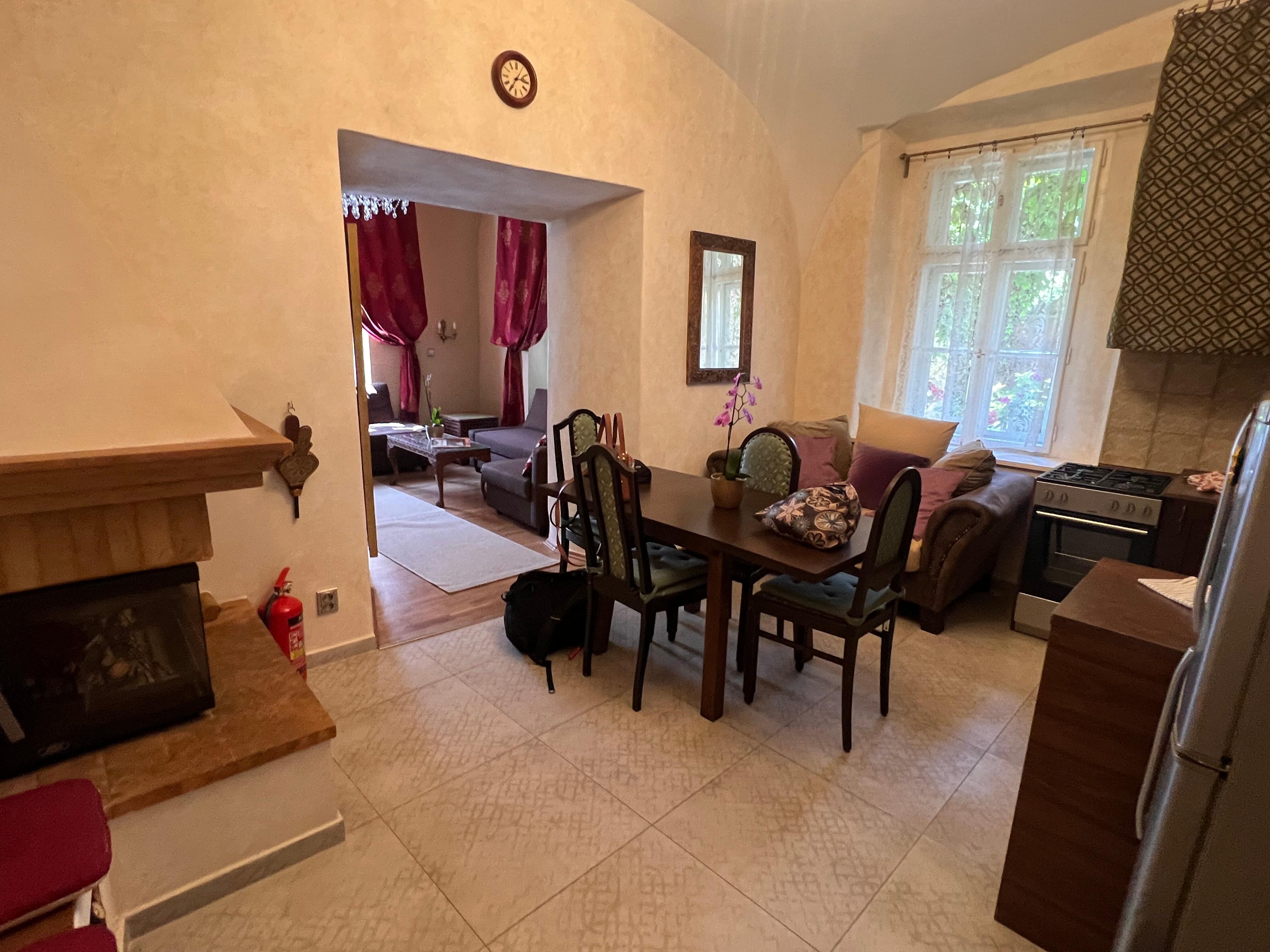 Large kitchen with eat in table and a couch under window to sit and chat with cook