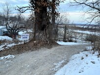 Driveway entry. Note white sign indicating entrance