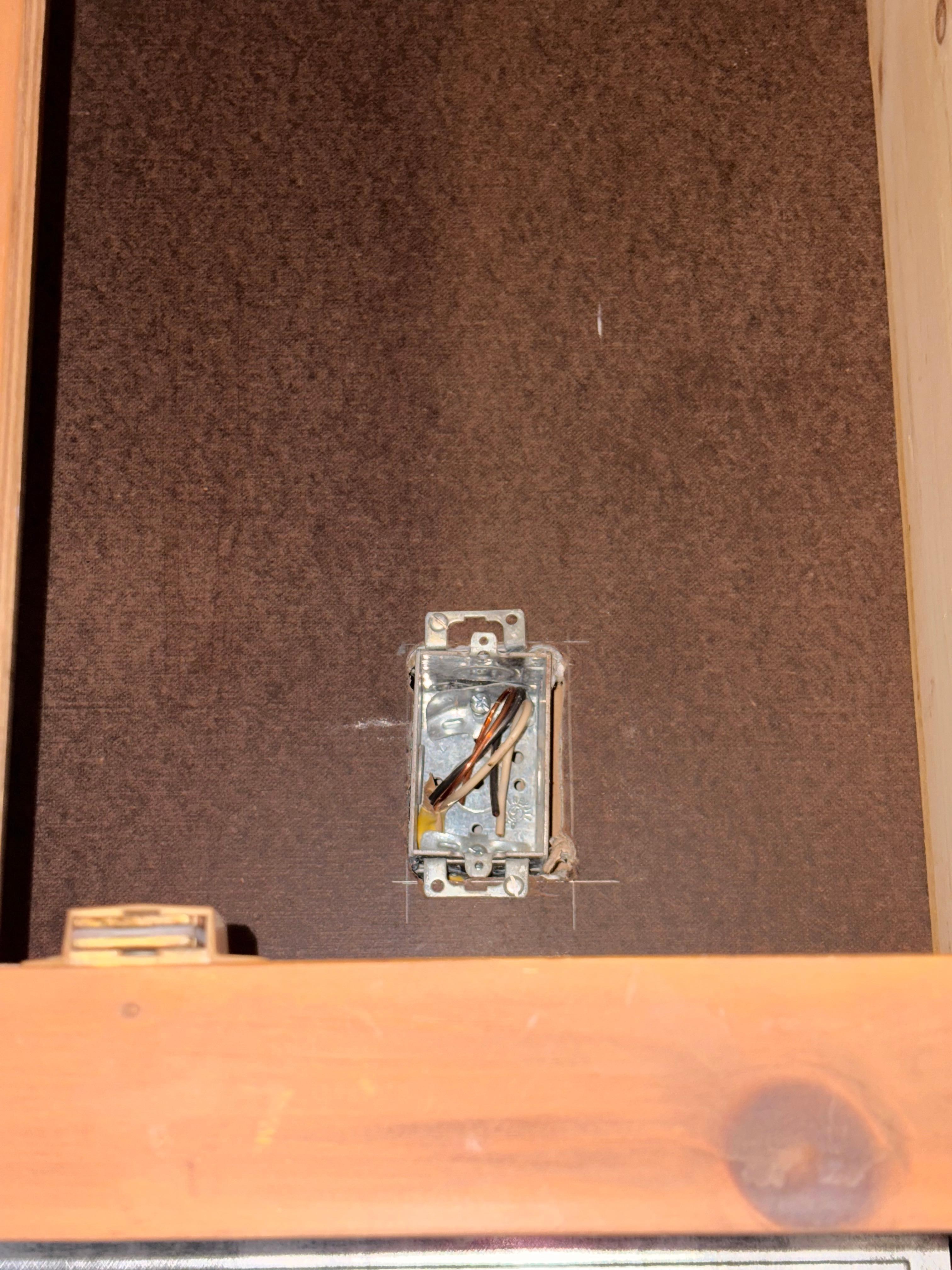 Exposed wires in cabinet above stove