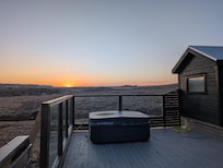 sunset with hot tub and guest house in foreground