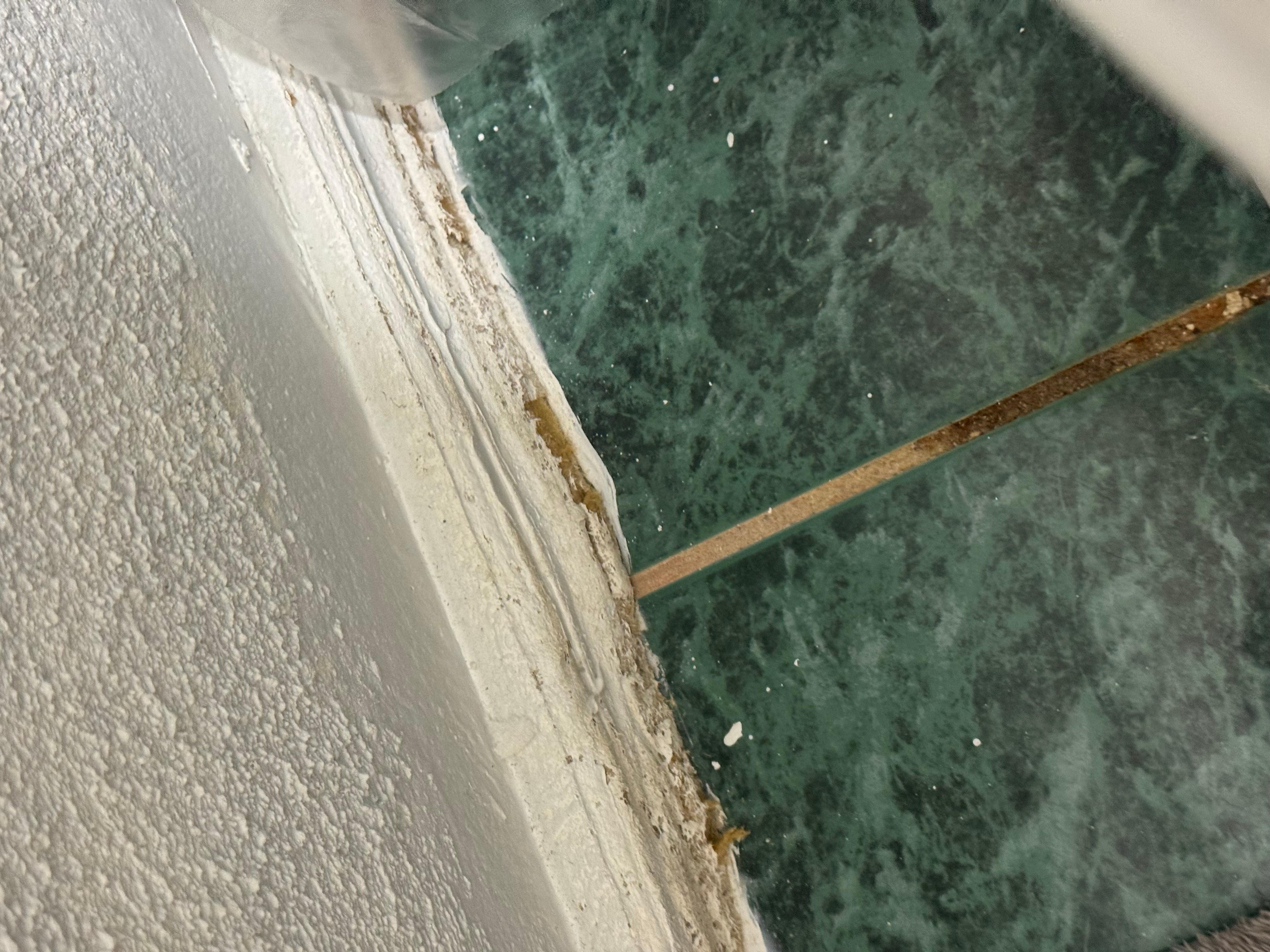 Dirty toilet area and warped baseboards 