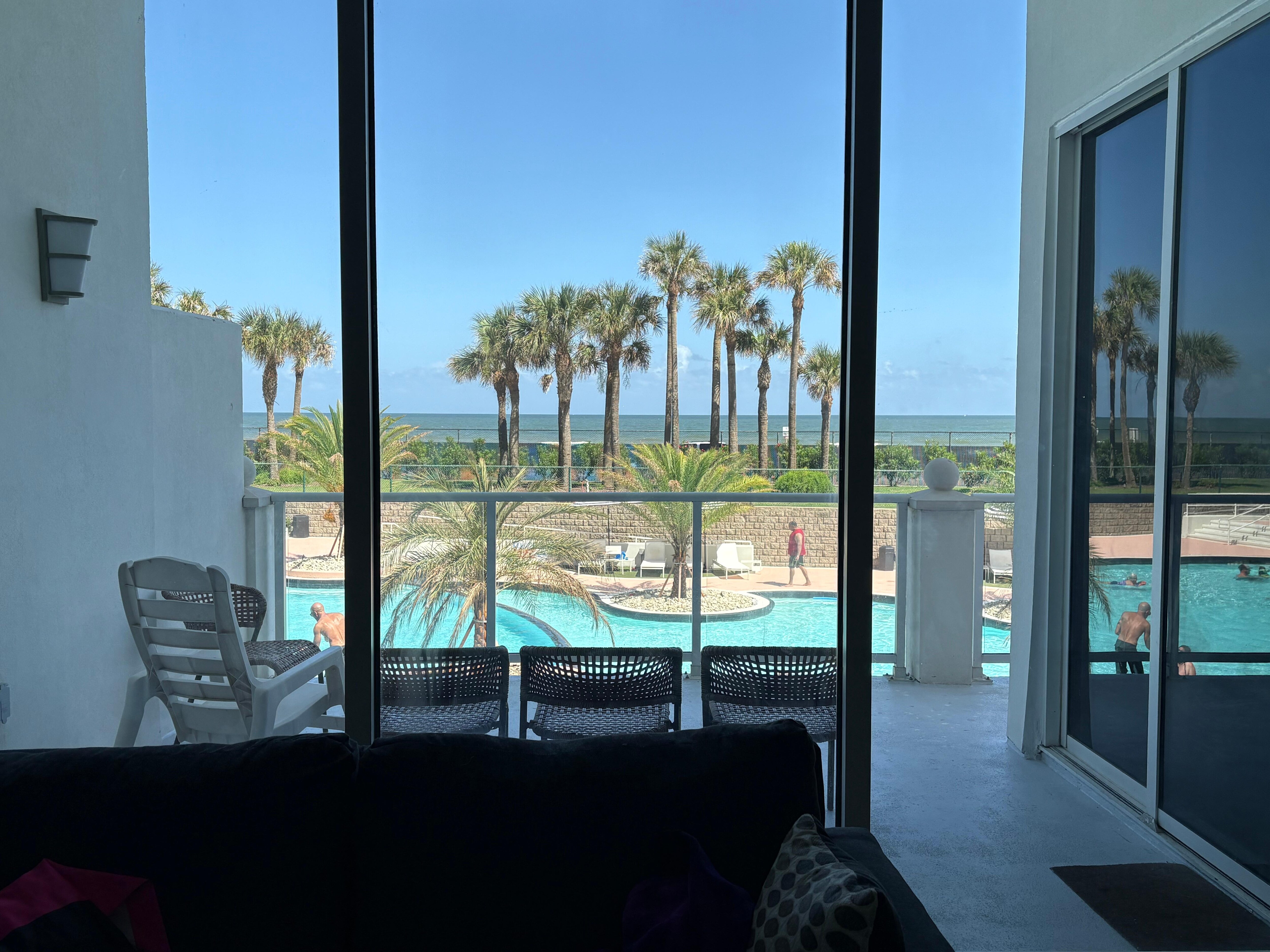 View from inside the condo overlooking the pool and ocean view.