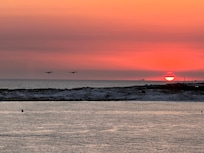Sunset off the deck with 2 C130’s flying towards us.