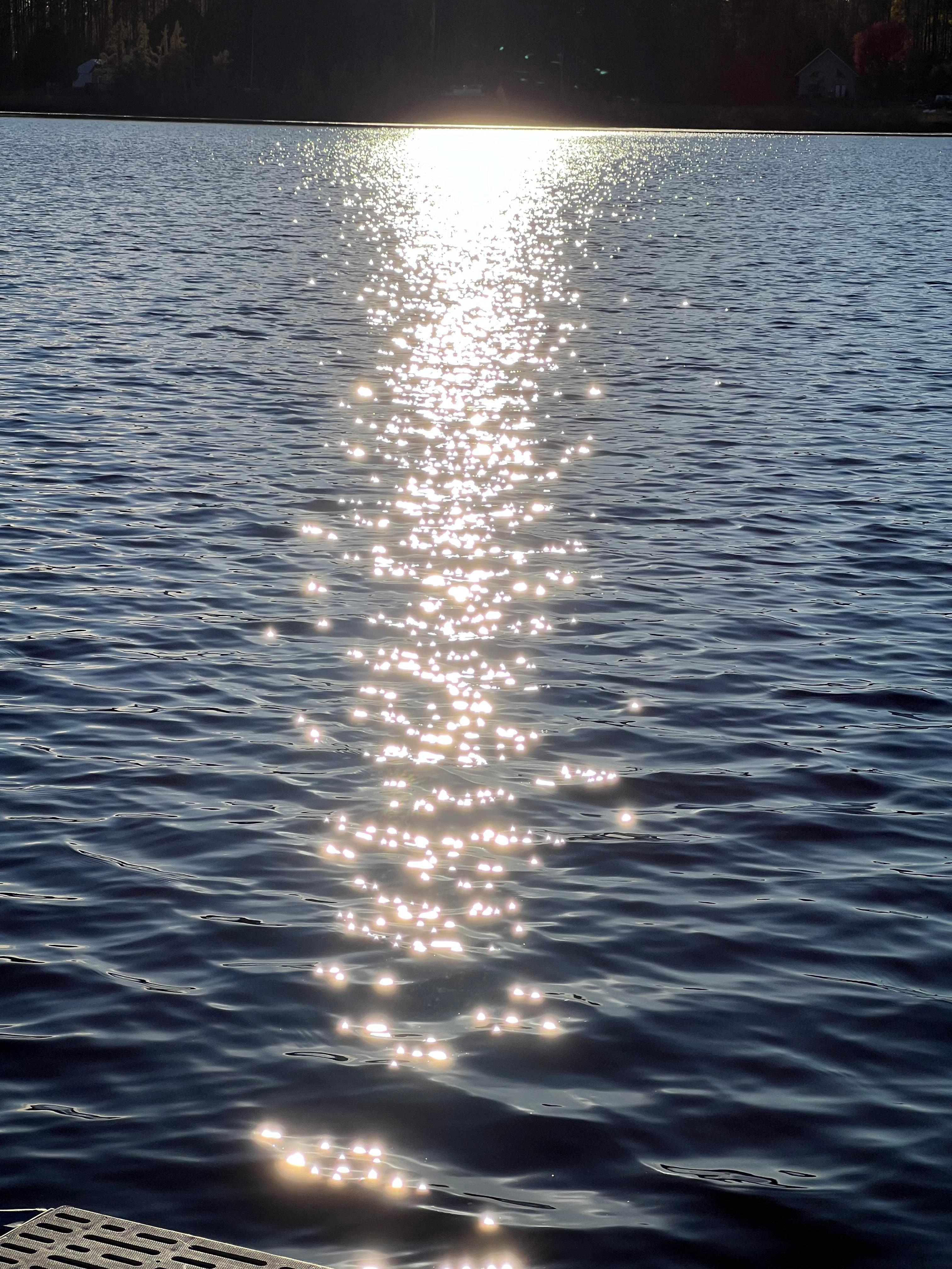 Shimmering lake sunset. Diamonds on the water. 