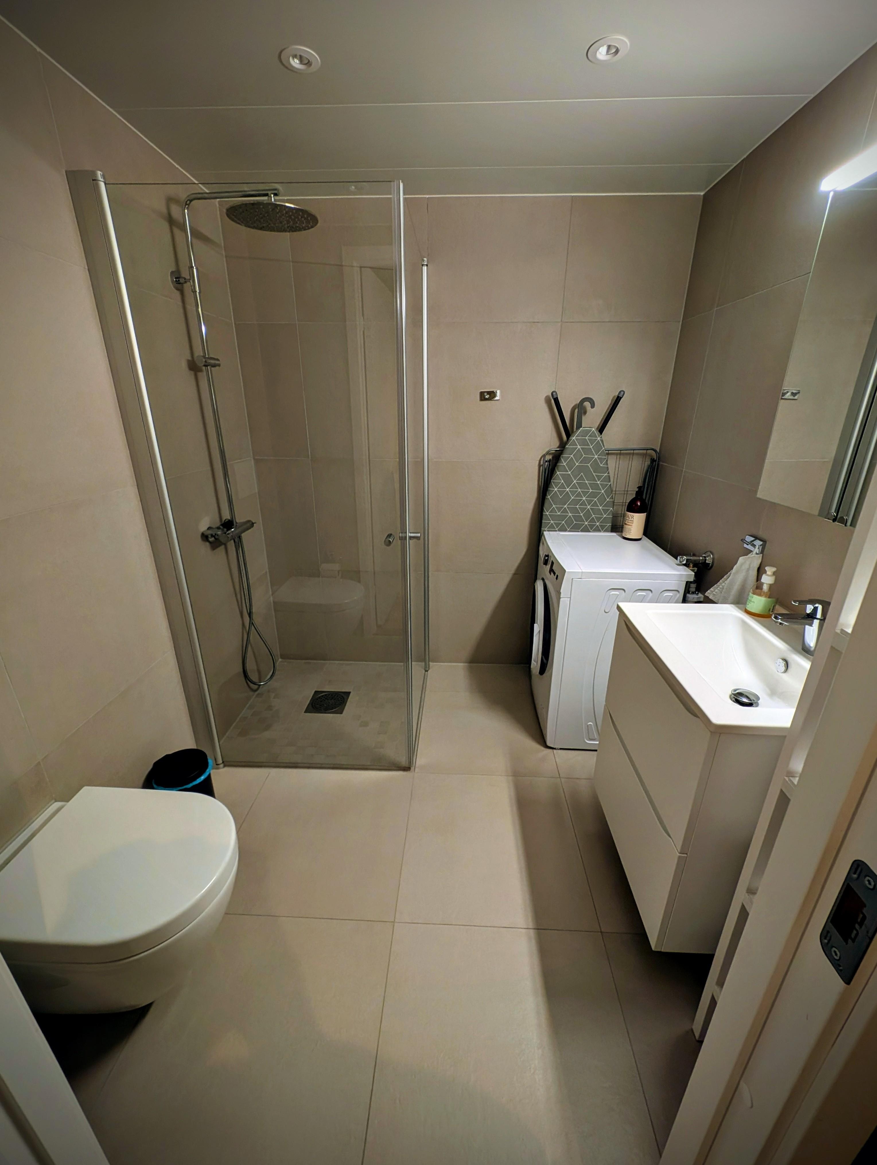 Badezimmer mit Dusche und Waschmaschine