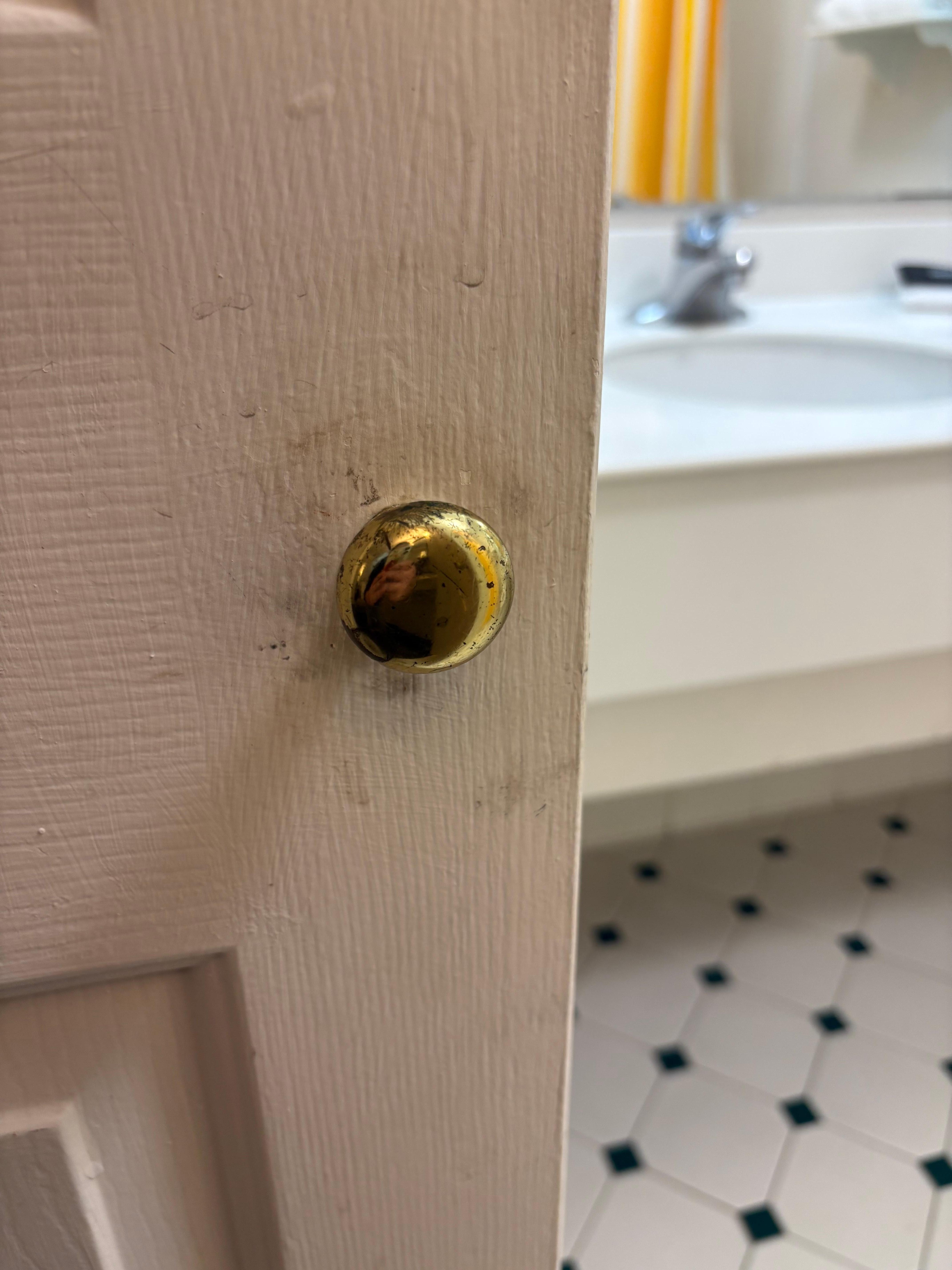 One outer bathroom door handle with caked dirt 