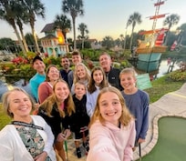 The 12 of us playing miniature golf.
