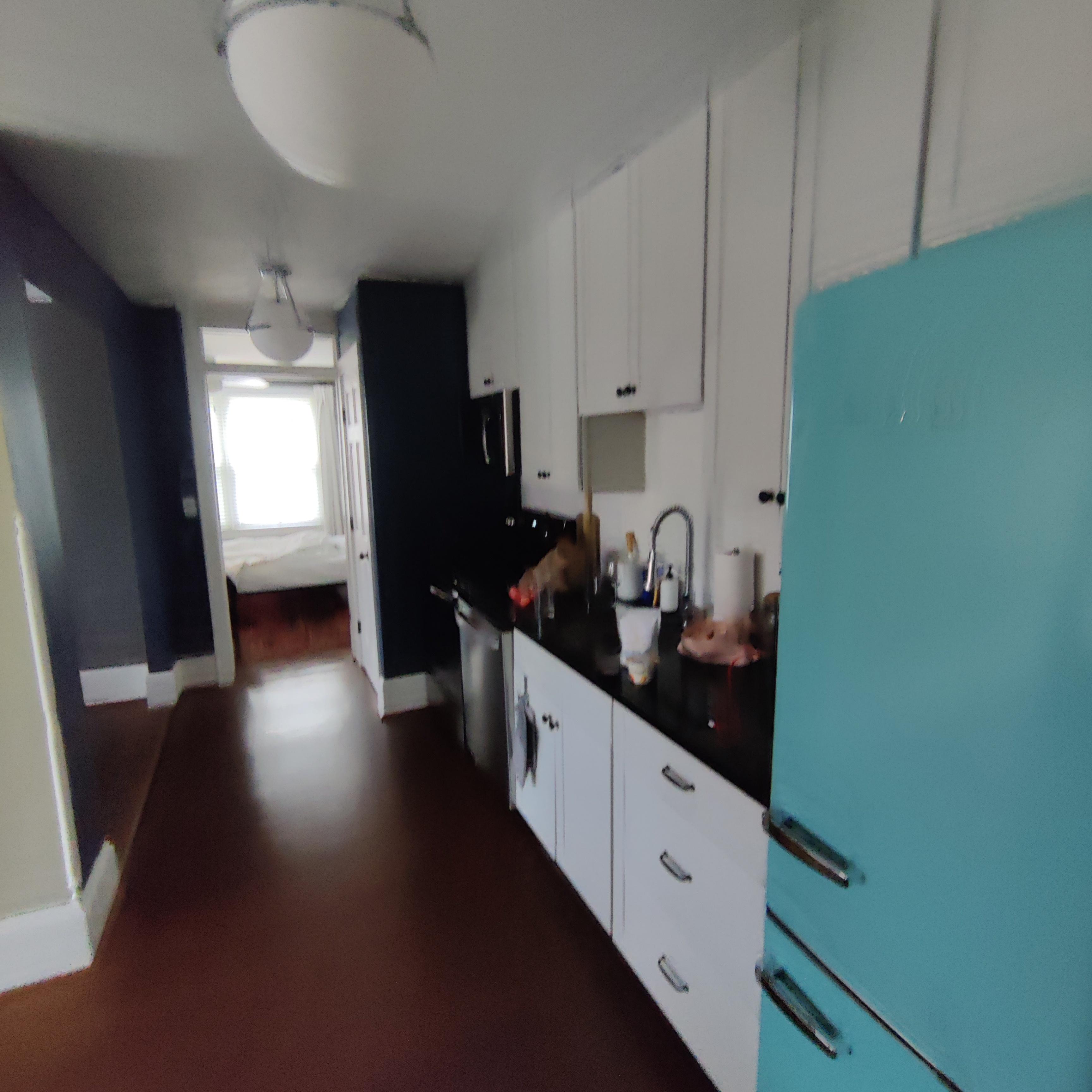 Kitchen through to bedroom. The refrigerator is art deco!