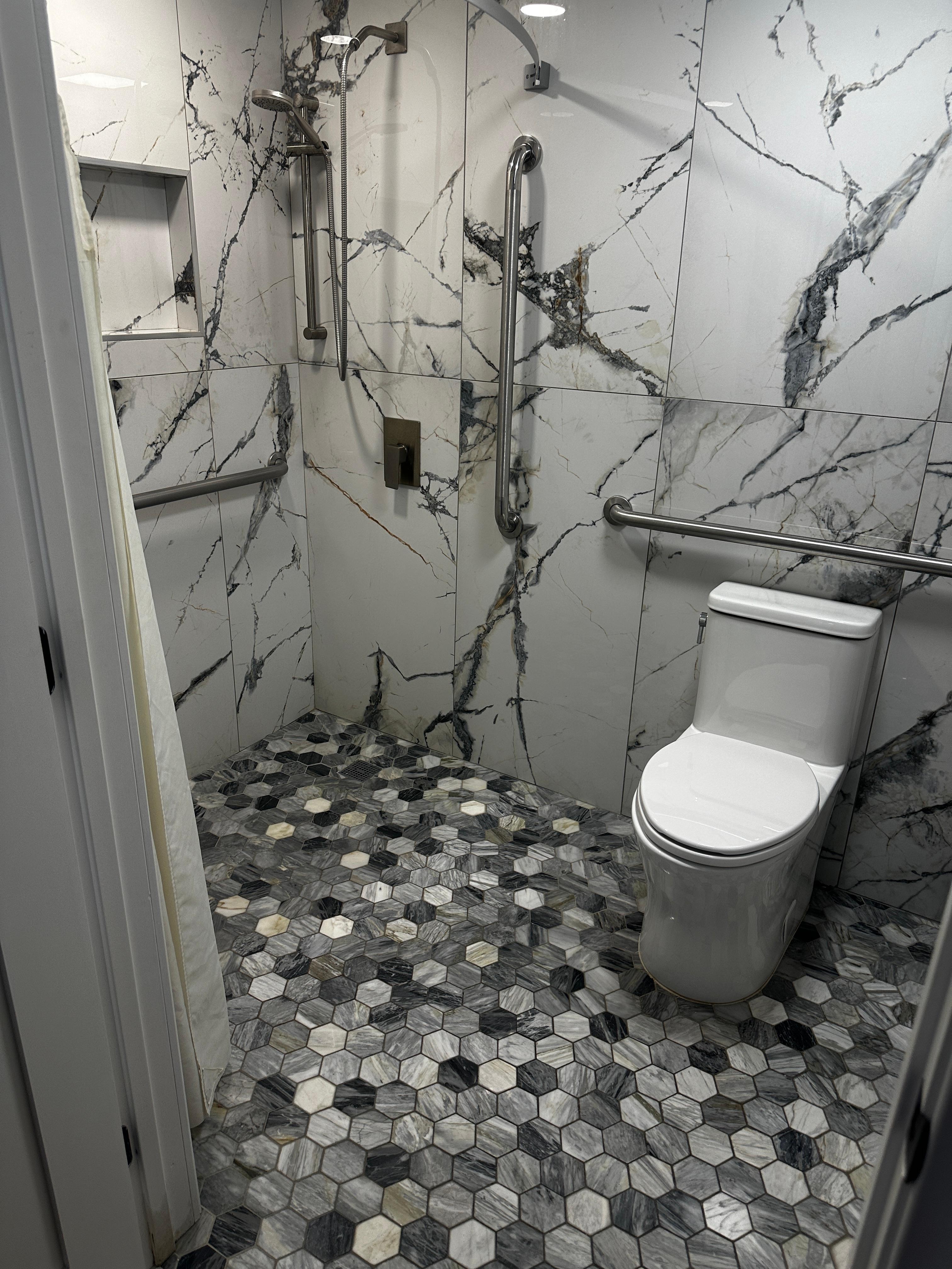 No tub or rail to define shower from toilet. Actual color of bathroom not black and whites.