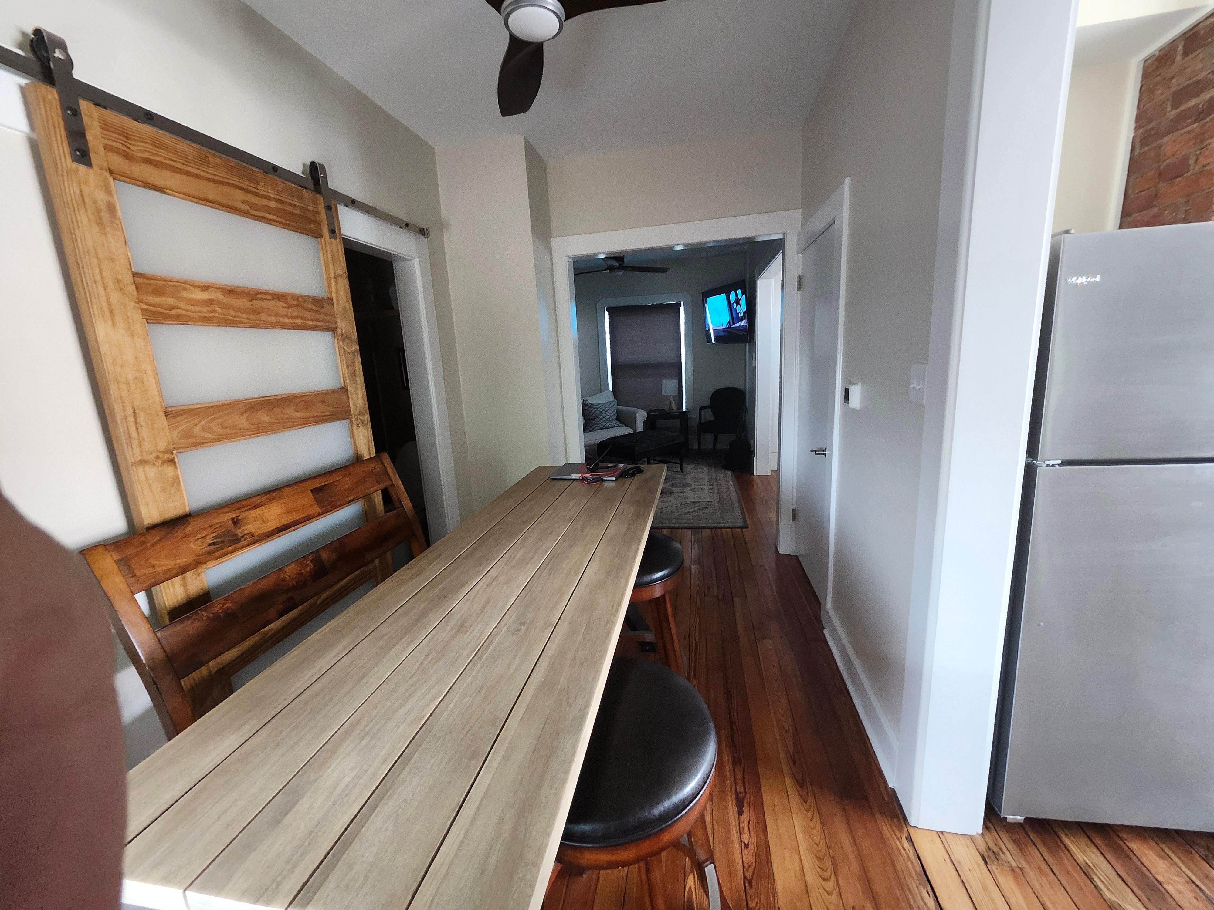 Dining area. Kitchen on the right, bathroom on the left with a sliding door and living room at the end.